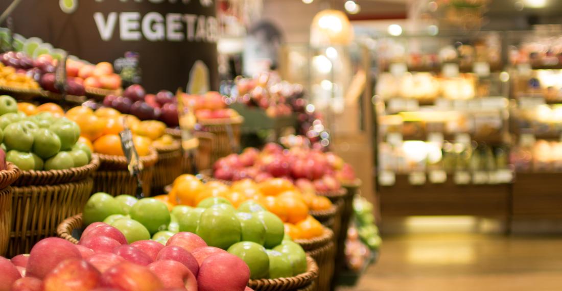 Buckets of apples at a grocery store.