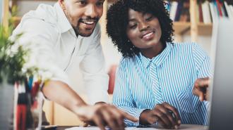 Two people looking at the computer.